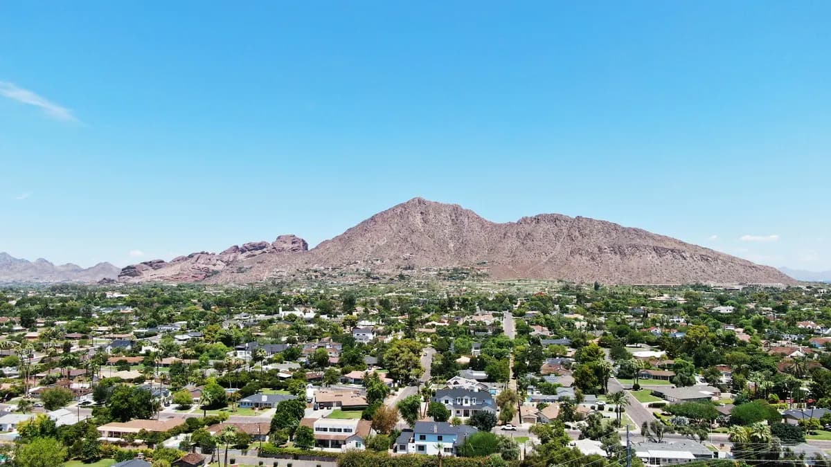Aerial view of Camelback Mountain above tree-lined neighborhoods in Phoenix, Arizona