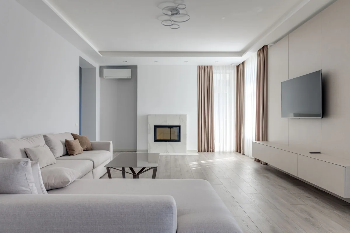 Bright, tidy living room with a light sofa, wood floor and sheer curtains