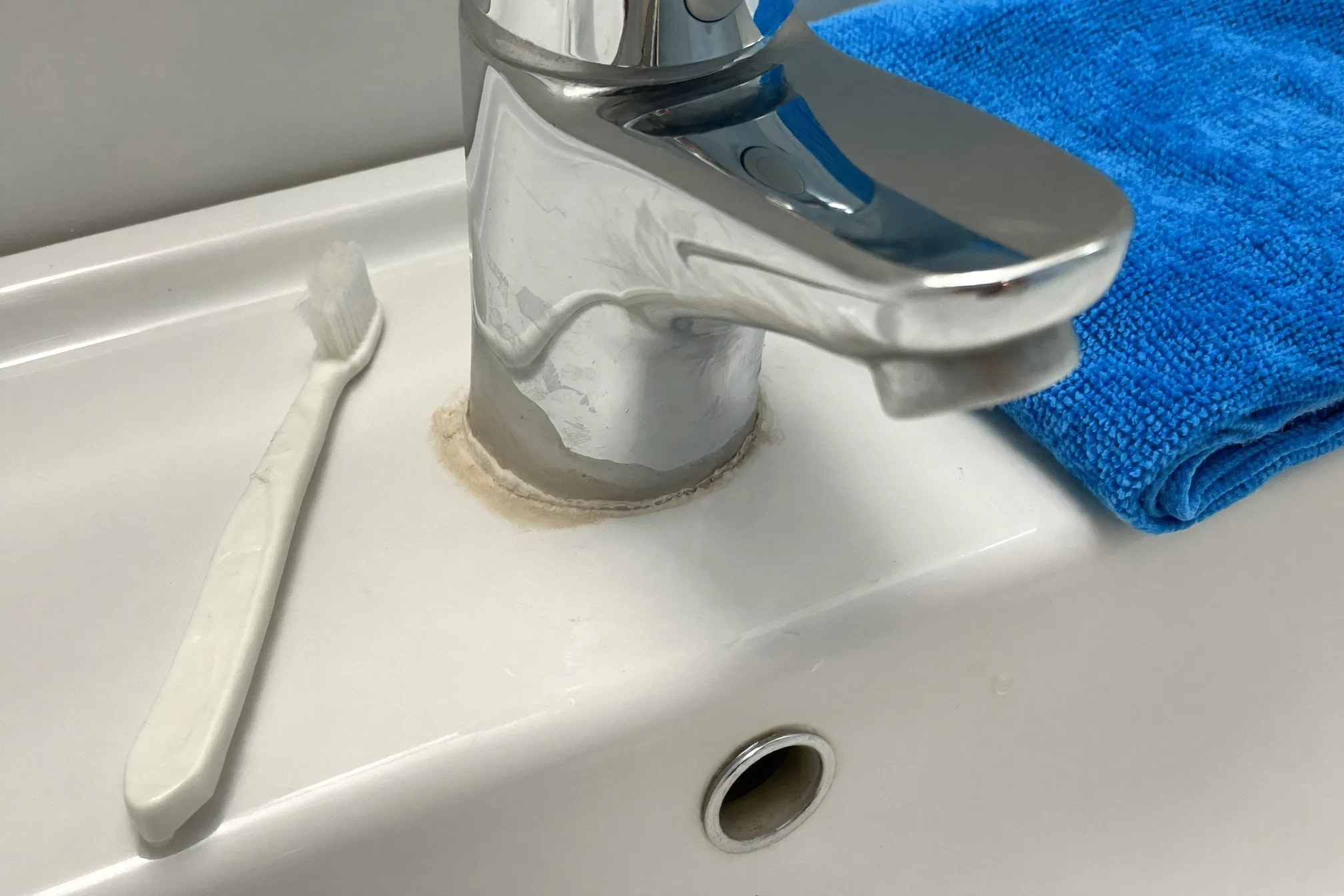 Hard water ring around a bathroom faucet base ready for cleaning