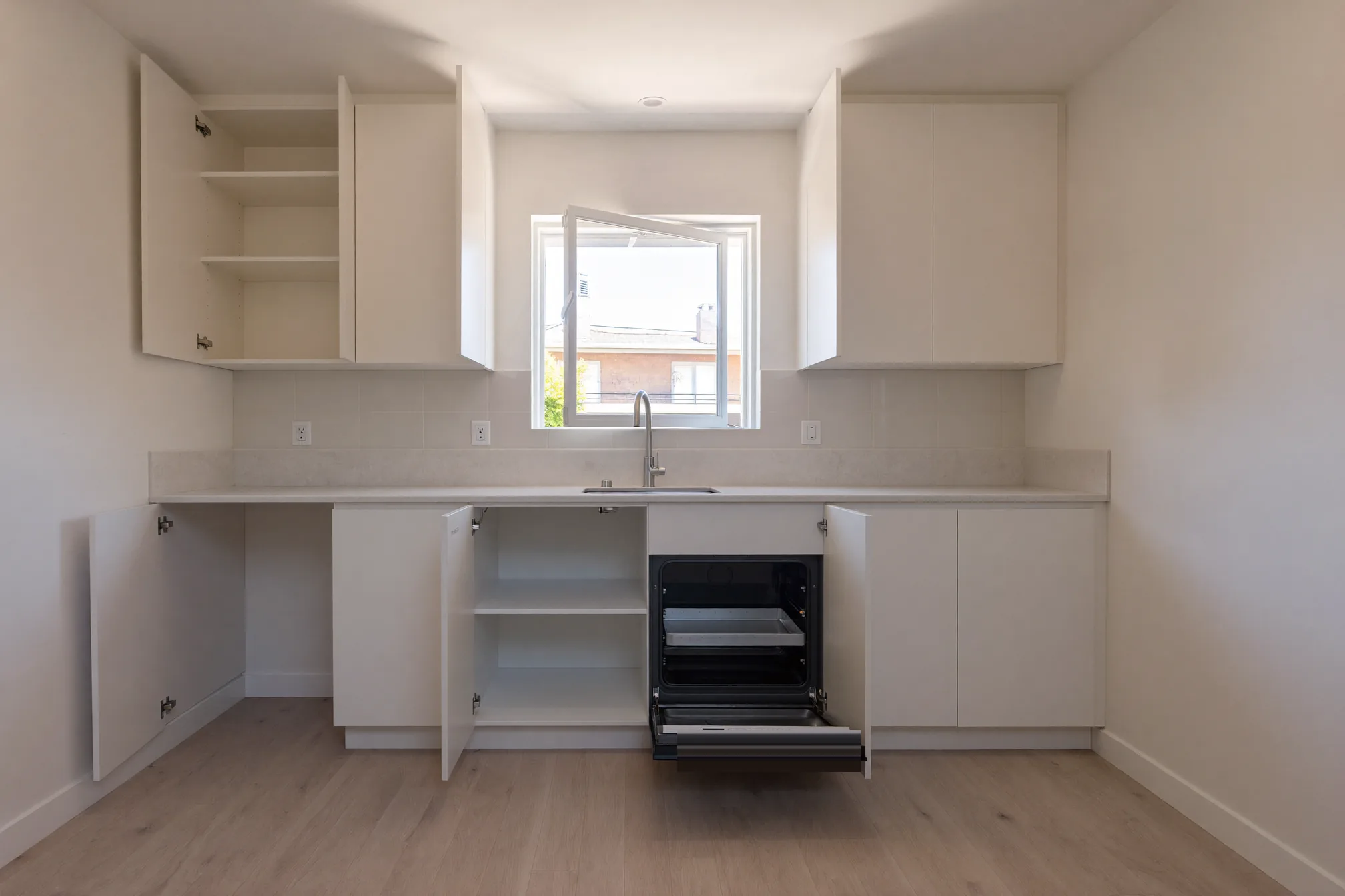 Open oven and empty clean kitchen cabinets in a vacant home ready for move-in