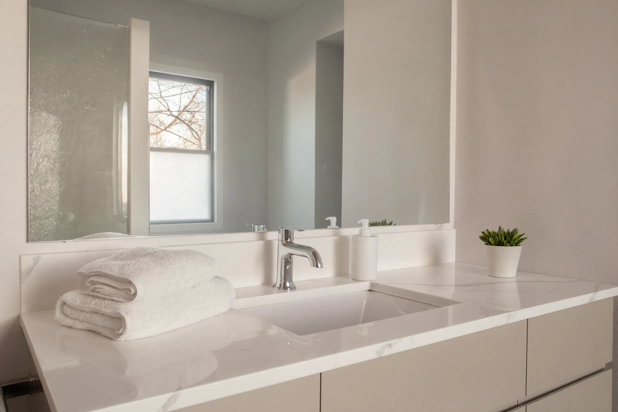 Clean guest bathroom sink with fresh hand towels